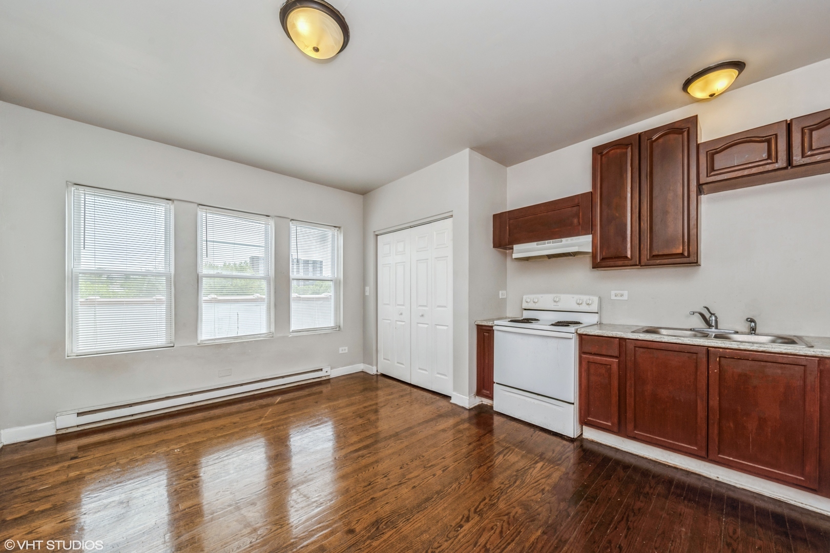 1506 East 67th Street, Unit 208 Chicago, IL 60637 - Photo 2 of 7 a kitchen with stainless steel appliances granite countertop a sink a stove cabinets and wooden floor