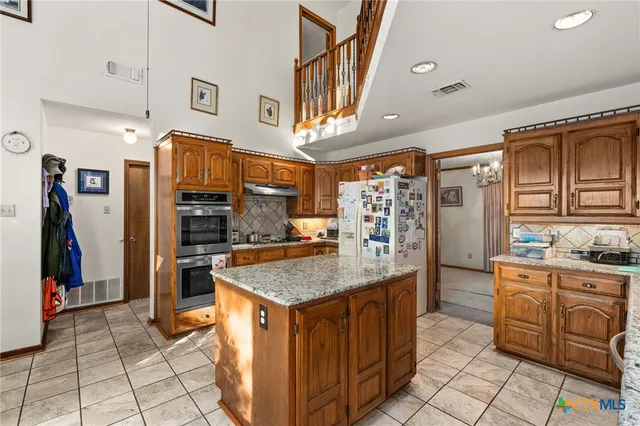 a kitchen with stainless steel appliances granite countertop a sink and cabinets
