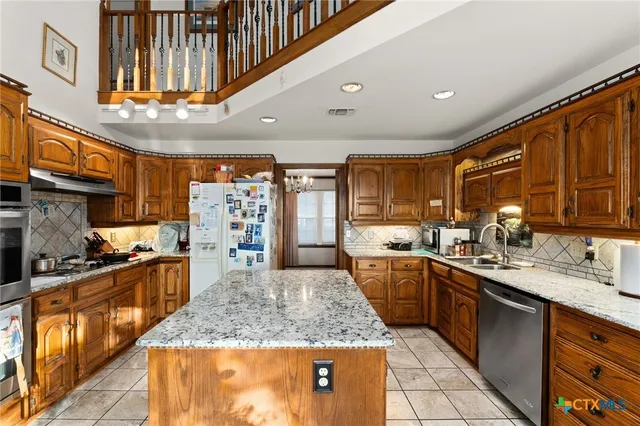 a large kitchen with stainless steel appliances granite countertop a large stove a sink dishwasher and cabinets