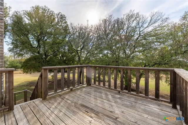 a balcony with wooden floor and fence