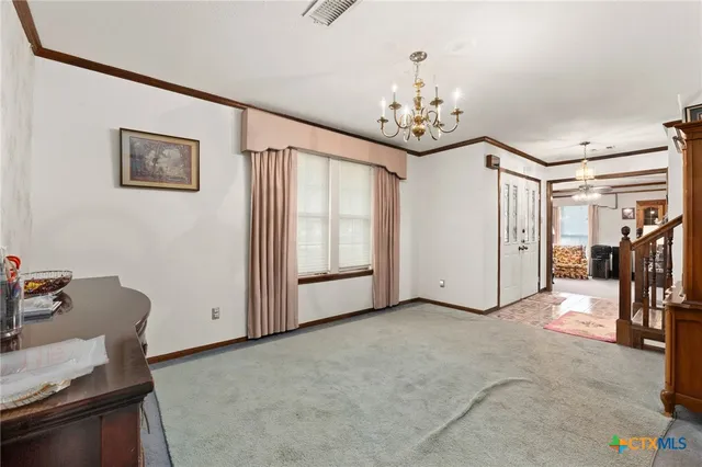a view of a livingroom with a chandelier furniture and windows