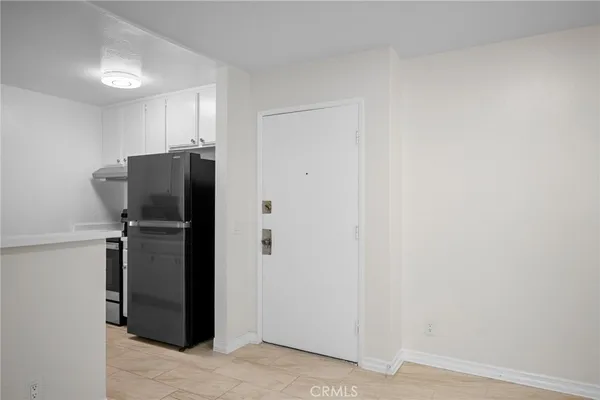 a view of a refrigerator in kitchen and utility room