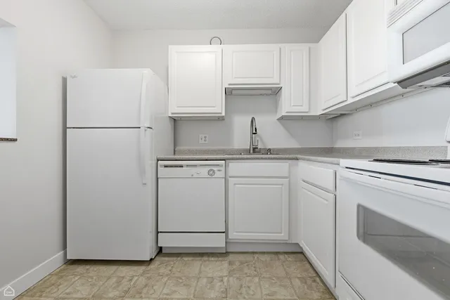 a kitchen with white cabinets and white appliances