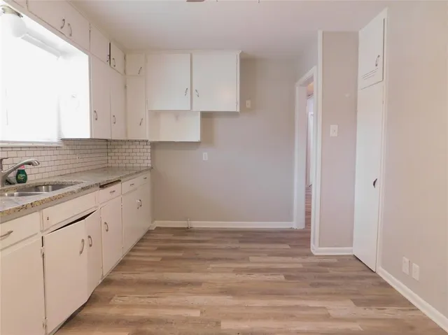 a kitchen with granite countertop white cabinets and white appliances
