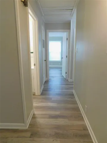 a view of a hallway with wooden floor
