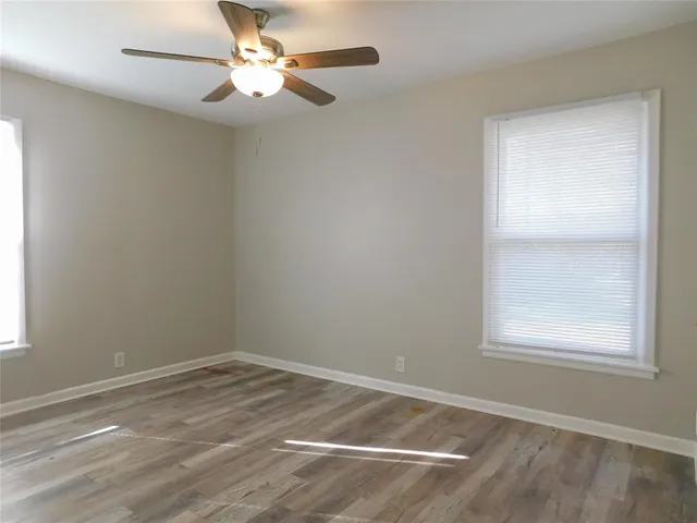 an empty room with a window and a fan