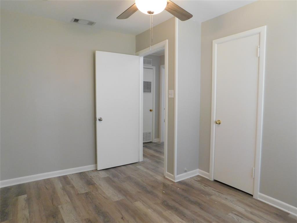 819 Thomas Street Denton, TX 76201 - Photo 22 of 33 an empty room with wooden floor and a ceiling fan