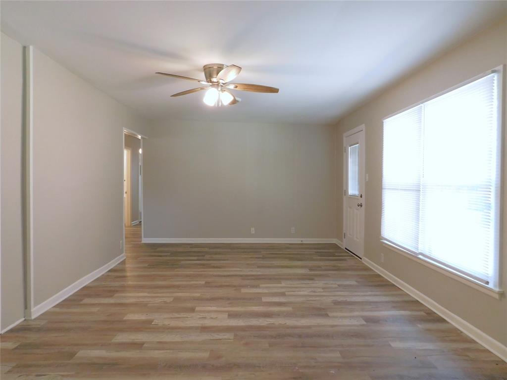 819 Thomas Street Denton, TX 76201 - Photo 9 of 33 an empty room with wooden floor fan and windows