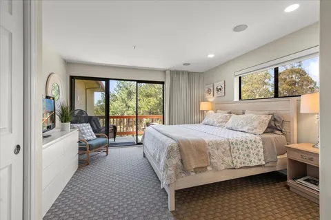 a bedroom with a bed a couch and a flat screen tv