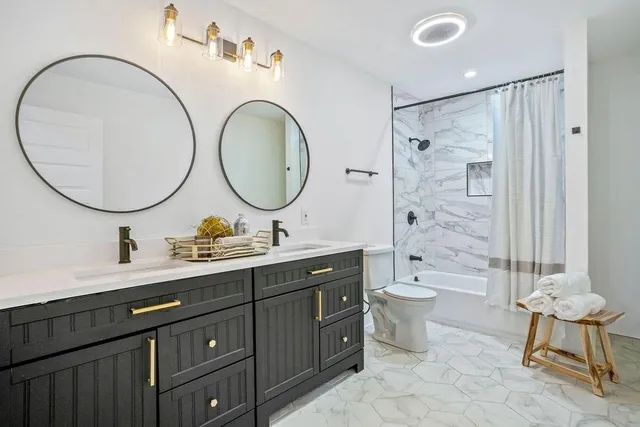 a bathroom with a double vanity sink mirror and toilet