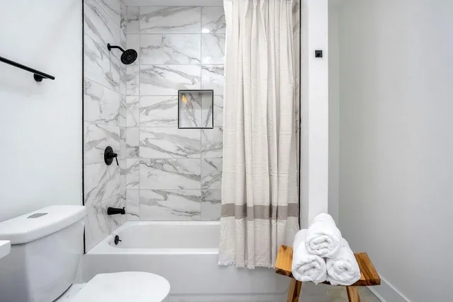 a bathroom with a toilet and a shower curtain