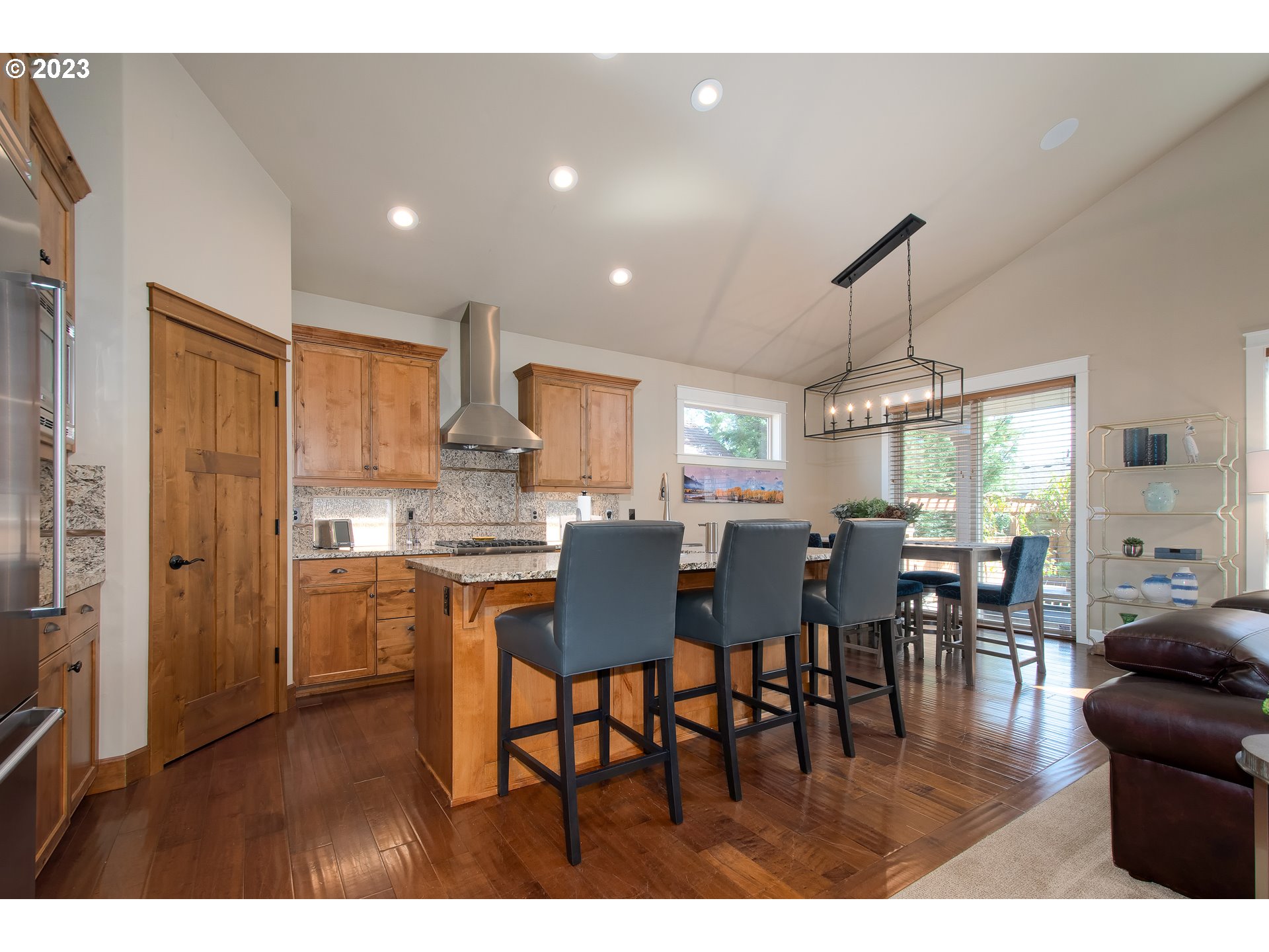 12918 Southwest Sevilla Avenue Portland, OR 97223 - Photo 13 of 44 a kitchen with stainless steel appliances granite countertop a dining table chairs stove a refrigerator and cabinets