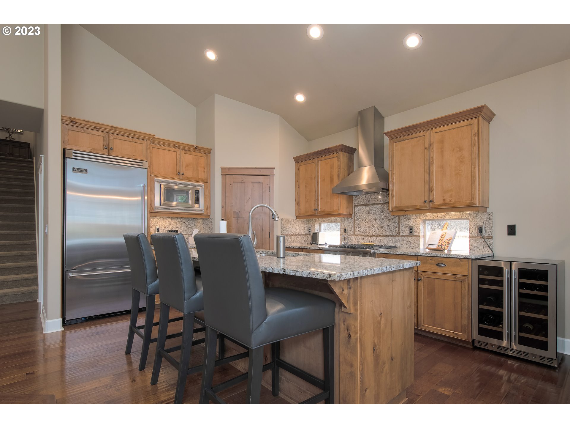 12918 Southwest Sevilla Avenue Portland, OR 97223 - Photo 14 of 44 a kitchen with stainless steel appliances granite countertop a table chairs sink refrigerator and cabinets