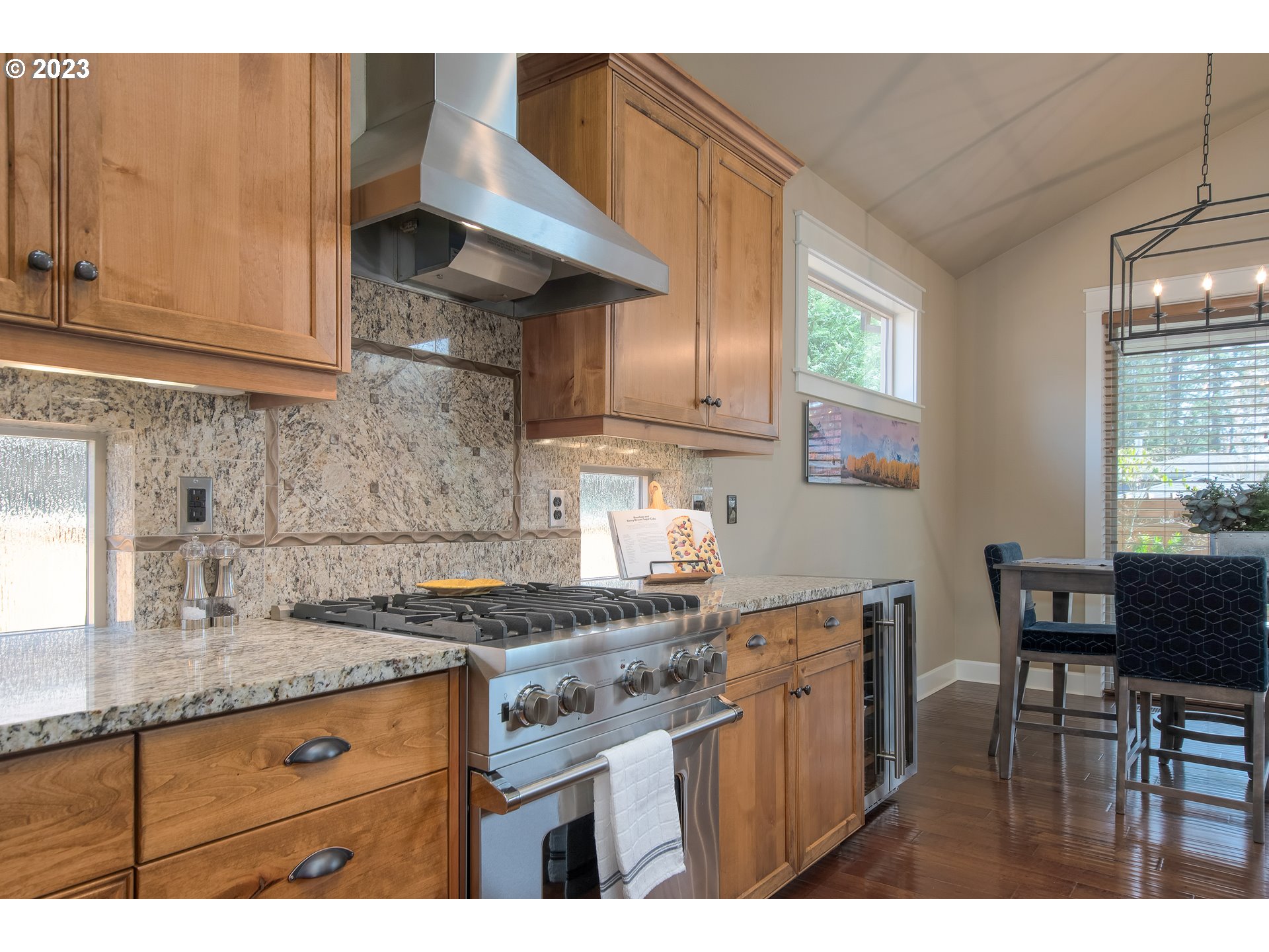 12918 Southwest Sevilla Avenue Portland, OR 97223 - Photo 18 of 44 a kitchen with granite countertop a table chairs stove and cabinets