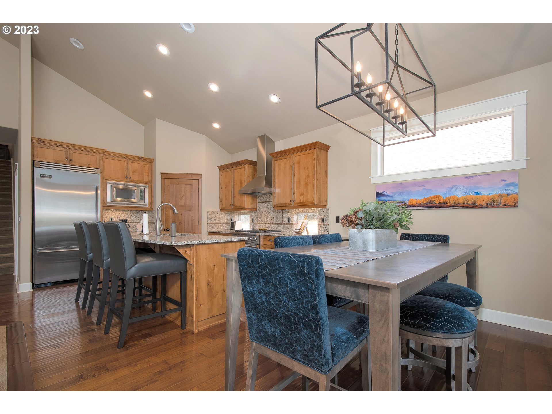 12918 Southwest Sevilla Avenue Portland, OR 97223 - Photo 20 of 44 a kitchen with stainless steel appliances kitchen island granite countertop a table chairs and a refrigerator