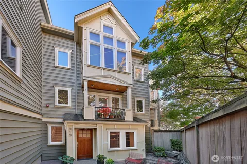 a view of a house with a tree and wooden fence