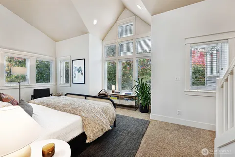 a spacious bedroom with a bed and glass windows