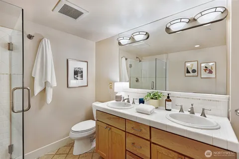 a bathroom with a granite countertop sink a toilet and a mirror