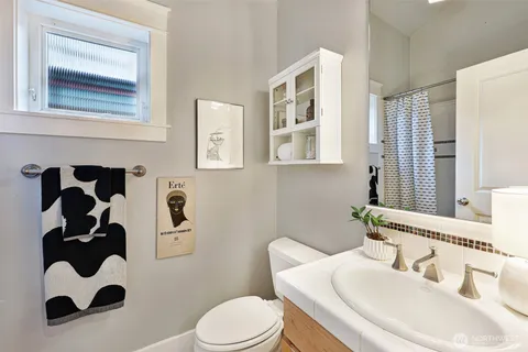 a bathroom with a sink a toilet and a mirror