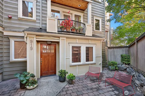 a view of a house with potted plants and a table and chair