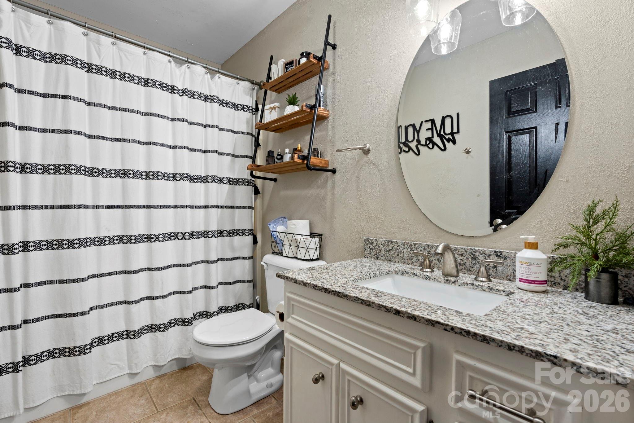 5750 Ellenwood Road Granite Falls, NC 28630 - Photo 20 of 38 a bathroom with a granite countertop bathtub sink vanity mirror and toilet