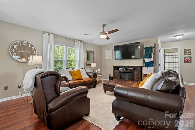 a living room with furniture ceiling fan and a wooden floor