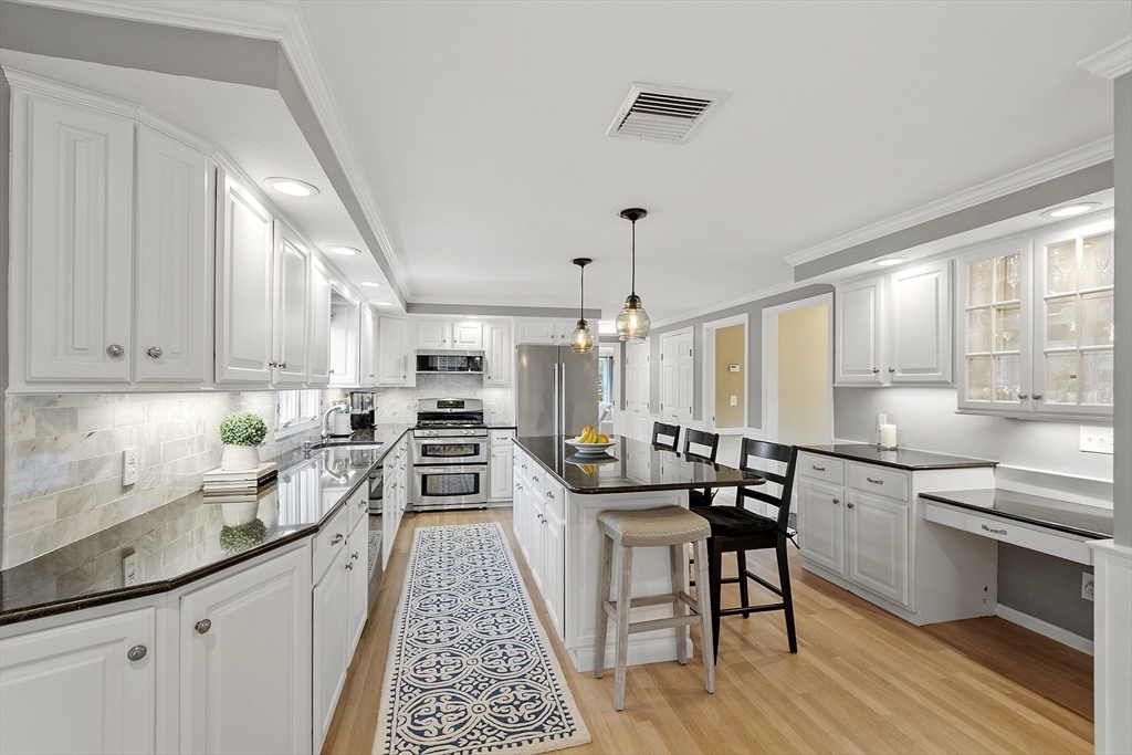 3 Baldwin Road Westford, MA 01886 - Photo 7 of 42 a kitchen with lots of counter top space and dining table