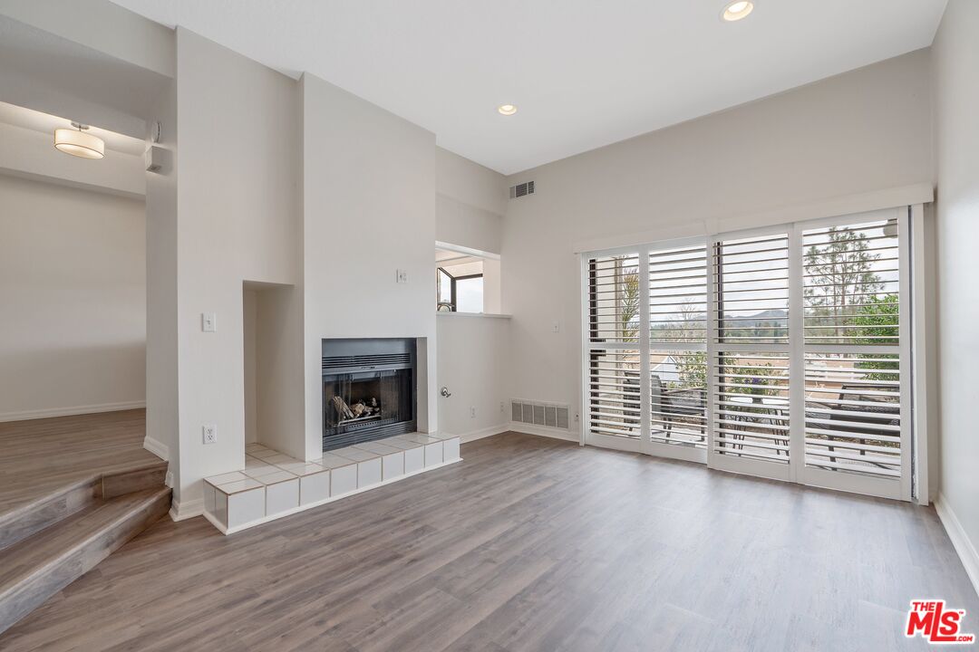 5728 Skyview Way, Unit E Agoura Hills, CA 91301 - Photo 1 of 28 an empty room with wooden floor and fireplace