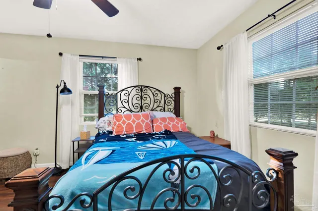 a bedroom with a bed a dresser with wooden floor