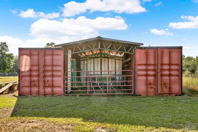 a aerial view of a house in a big yard with potted plants and large tree