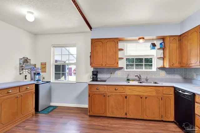 a kitchen with a sink cabinets and wooden floor