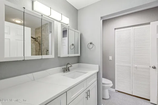 a bathroom with a sink a toilet and shower