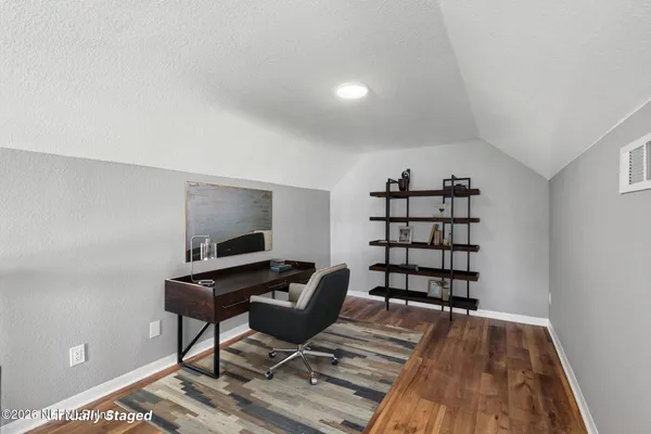 a view of a workspace with furniture and wooden floor