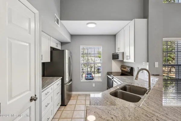 a kitchen with granite countertop a sink appliances and cabinets
