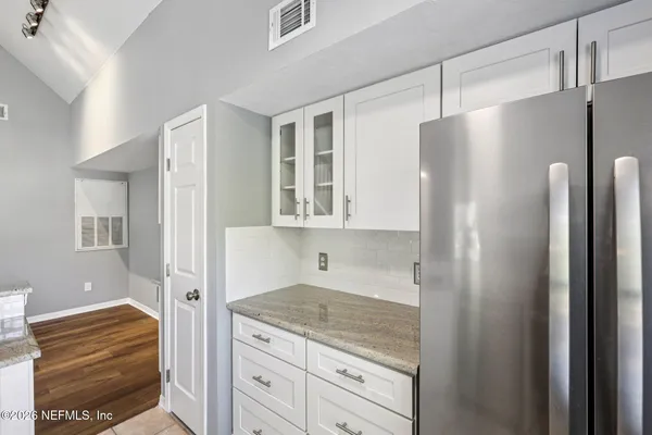 a kitchen with granite countertop a refrigerator and a sink