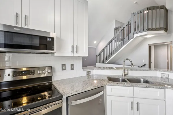 a kitchen with a stove and a white cabinets