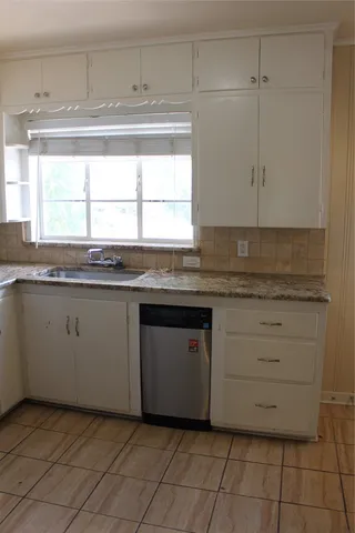 a kitchen with granite countertop white cabinets and white appliances