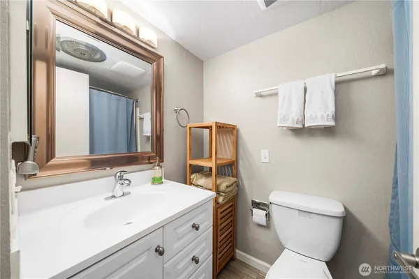 a bathroom with a sink toilet and mirror
