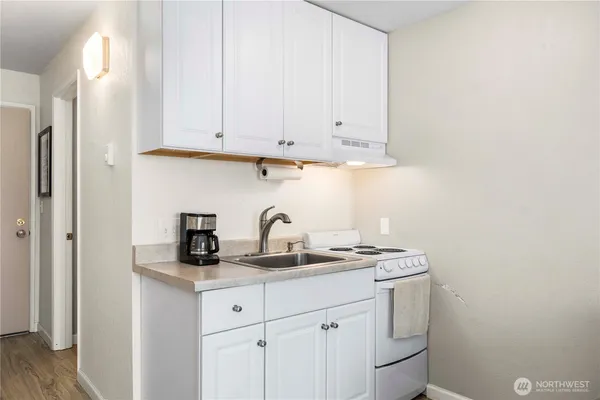 a kitchen with stainless steel appliances granite countertop white cabinets and a sink