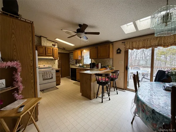a kitchen with stainless steel appliances kitchen island granite countertop a table chairs and a refrigerator