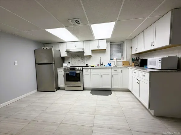 a kitchen with stainless steel appliances granite countertop a sink a stove a refrigerator and cabinets