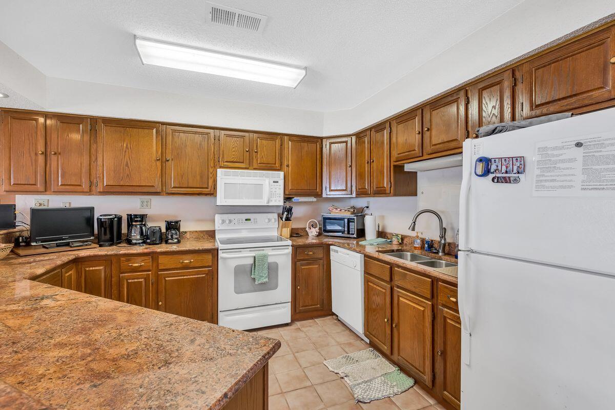 332 Blue Mountain Road Santa Rosa Beach, FL 32459 - Photo 27 of 50 a kitchen with stainless steel appliances granite countertop a stove sink refrigerator and cabinets