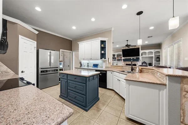 a kitchen with stainless steel appliances kitchen island granite countertop a sink stove and refrigerator