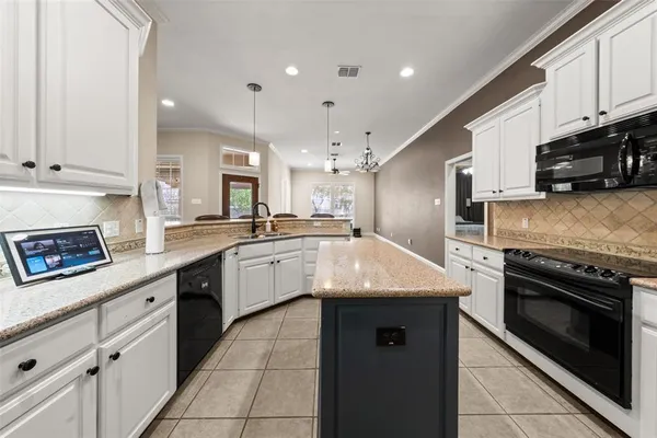 a kitchen with granite countertop a sink stainless steel appliances and cabinets