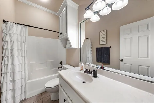 a bathroom with a sink a toilet a mirror and shower