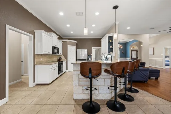 a kitchen with cabinets and chairs