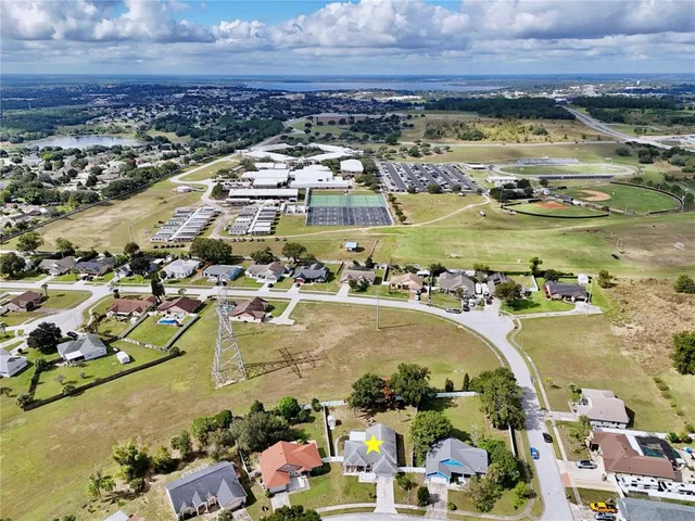 an aerial view of residential houses with outdoor space and lake view