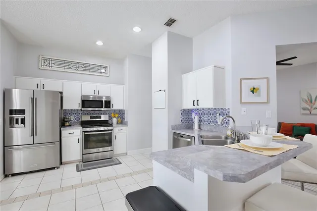 a kitchen with stainless steel appliances granite countertop a refrigerator and a stove