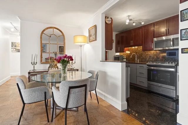 a kitchen with stainless steel appliances kitchen island granite countertop a table and chairs