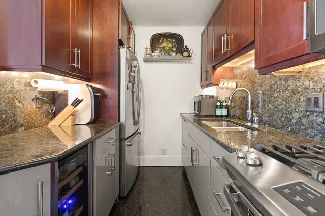 a kitchen with stainless steel appliances granite countertop a sink stove and refrigerator